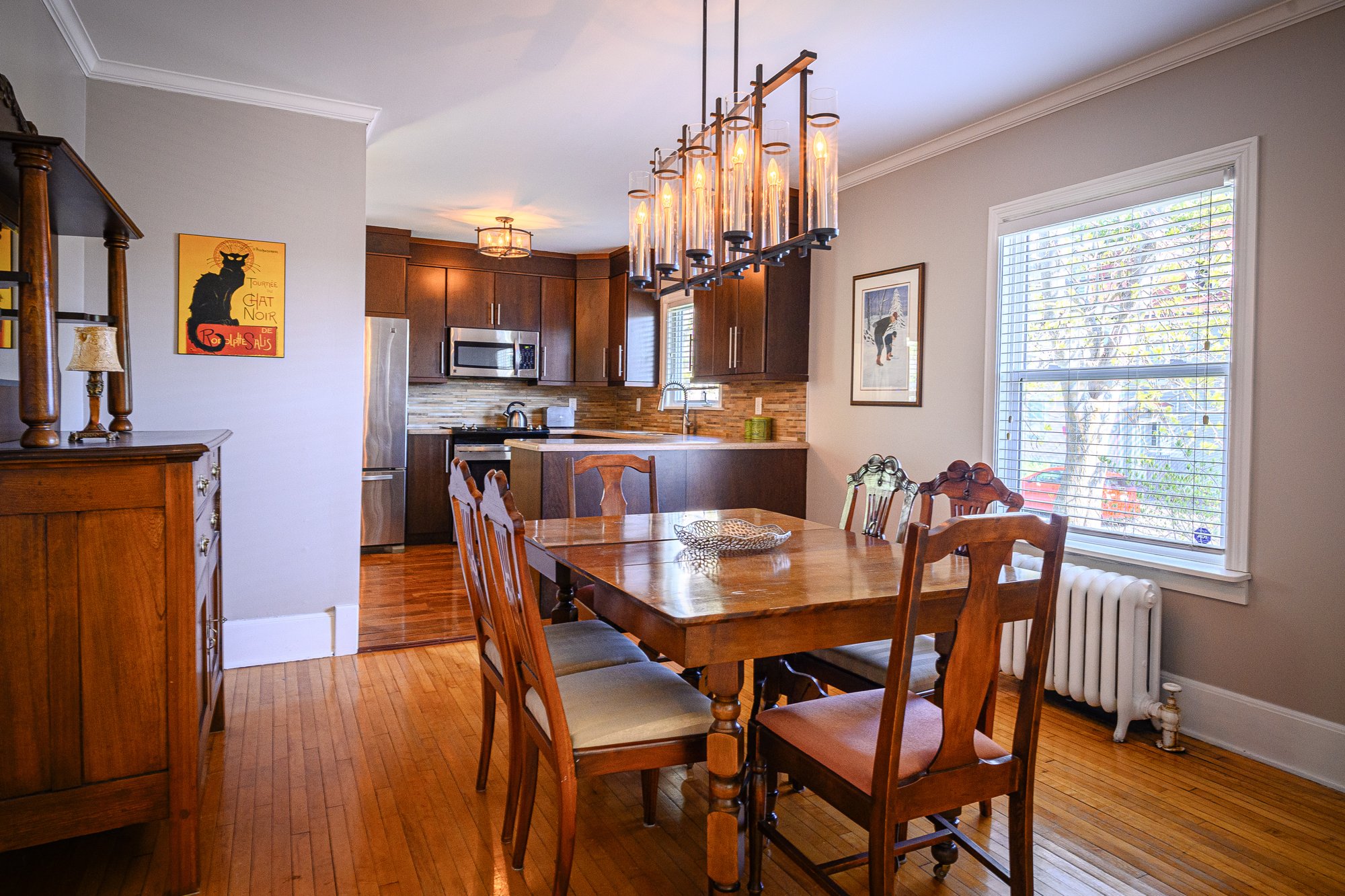 Dining table and pendant lights beside the furnished kitchen